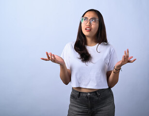 Asian woman with long dark hair, wearing glasses, a white crop top, and black jeans, raising both...