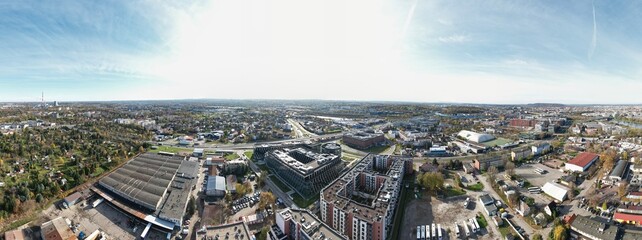 An aerial view of Kraków’s Zabłocie district, showcasing its dynamic transformation along the banks of the Vistula River. Once an industrial area, Zabłocie has evolved into a modern, thriving neighbor