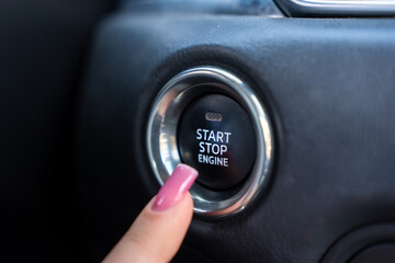 The female driver is trying to start the car's engine.