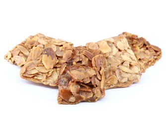 Pieces of almond crunch or almond brittle, traditional italian dessert, on white background.