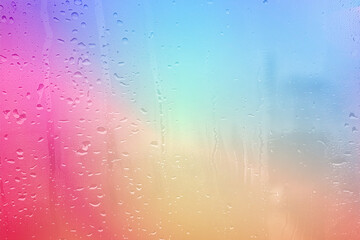 Abstract colorful background with raindrops on a glass window creating a textured wet surface
