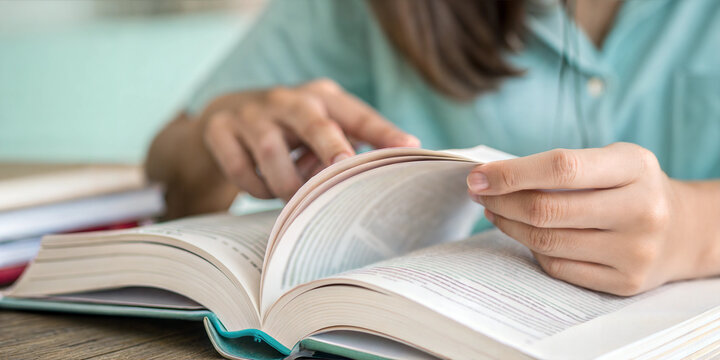 Student reading textbook while studying for exam, focused on learning and knowledge