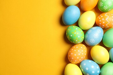 Beautiful decorated Easter eggs on orange background, flat lay. Space for text