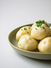 Savory raspeballer served with rich sauce on a light green plate against a muted backdrop