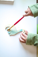 Toddler painting a dinosaur with watercolors