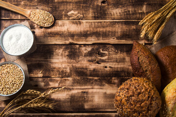 Various bread with wheat, flour and cooking utensils on stone table. Top view flat lay with copy space