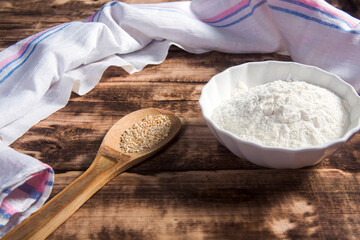 Oat flour  on dark wooden background.