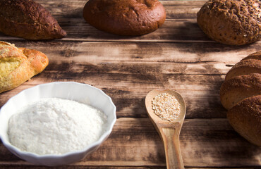 different breads,flour in wooden background