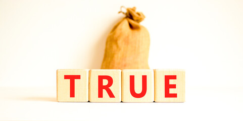 True symbol. Concept word True on beautiful wooden blocks. Beautiful canvas bag. Beautiful white...