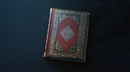 Fototapeta premium Beautiful ancient black book with golden decorations resting on dark stone surface