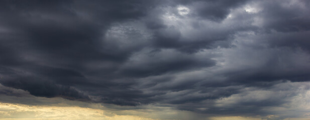 The dark sky, heavy with swirling clouds, signals an impending windstorm, highlighting the dramatic changes in weather and the immense power of nature.