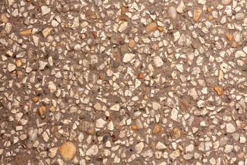 Rough terrazzo concrete texture with embedded stones
