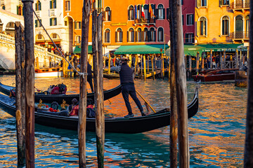 Venice Gondola on Canal: A serene image capturing a gondolier navigating the historic canals of Venice, Italy. The image focuses on the gondola.