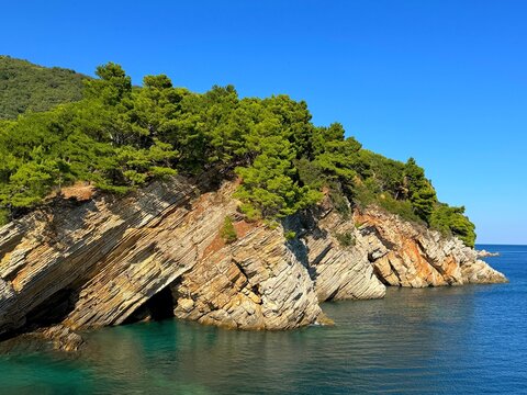 Amazing rocks composed of layered sandstone and clear turquoise sea in Montenegro.