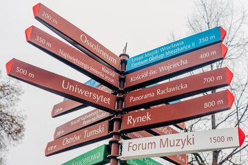 A city navigation signpost in Wroclaw, Poland, directing tourists to various attractions.