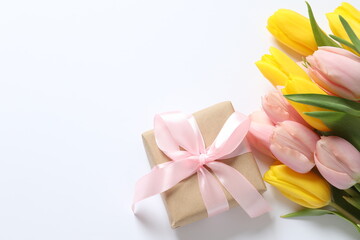 Beautiful fresh tulips with gift box on white background