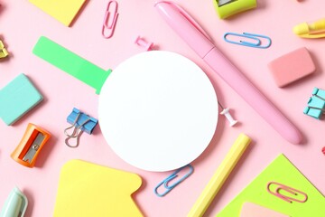 Flat lay with school stationery with paper card on pink background, top view