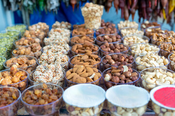 A variety of nuts at a street market in plastic containers