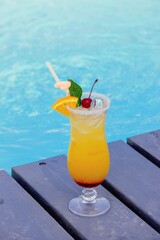 A nice cocktail, hat and sunglasses by the pool