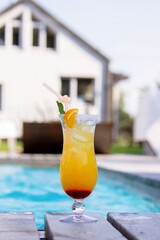 A nice cocktail, hat and sunglasses by the pool