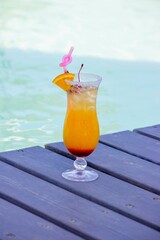 A nice cocktail, hat and sunglasses by the pool