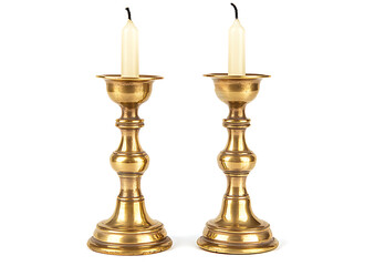 A pair of candlesticks with candles, made of brass material, in the European style, against a white background, captured in high-definition photography.