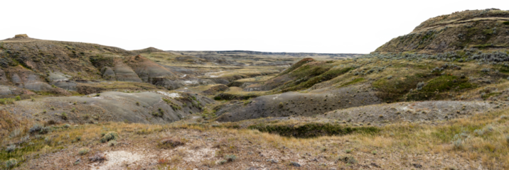 Rugged badlands desert hills with short dry autumn grass and distant mounds. Transparent sky. 
