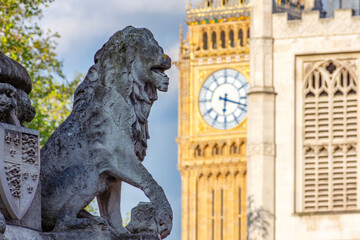 Lion sculpture of Scholars War Memorial at Westminster Abbey, St. Margaret church and Big Ben,...