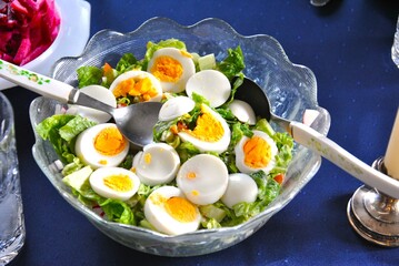 Delicious, healthy salad with egg, in a beautiful glass bowl.
