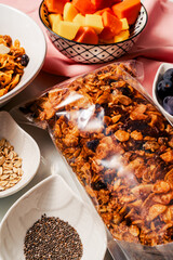 Healthy breakfast ingredients with handmade granola and fruits mango, papaya and grapes