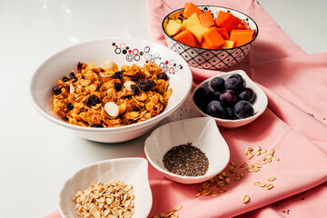Healthy breakfast ingredients with handmade granola and fruits mango, papaya and grapes