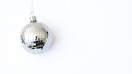 Fototapeta premium silver disco ball ornament hanging against white background