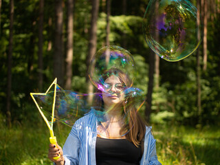 young girl blows beautiful and big soap bubbles