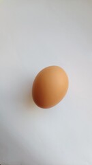 One brown chicken egg on a white background. Easter time.