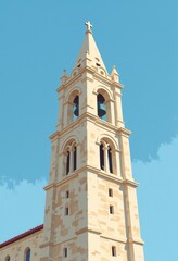 Obraz premium Minimalist Flat Color Illustration of a Tall Stone Church Bell Tower with Clear Blue Sky Background, Copy Space for Text
