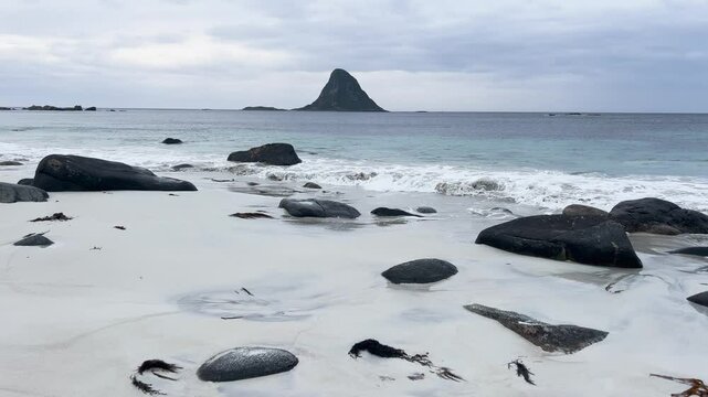 White sand beach with turquoise ocean water and a mountain in Bleik beach, Lofoten islands, Norway