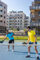 Obraz premium Two male athletes playing pickleball on a sunny day