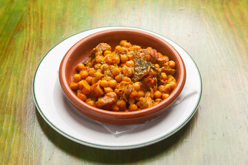 Chickpea and meat stew served in a traditional spanish earthenware bowl