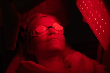 Woman undergoing red light therapy treatment in a wellness center