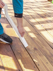 Man is painting a wooden deck