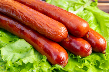 Fresh sausages resting on crisp green lettuce leaves