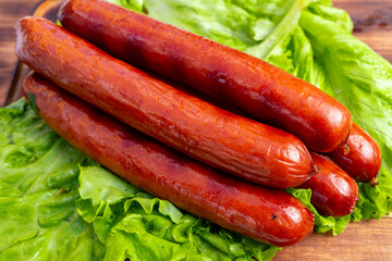 Juicy sausages resting on fresh green lettuce leaves