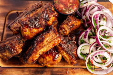 Delicious barbecue ribs served with fresh onion salad and salsa