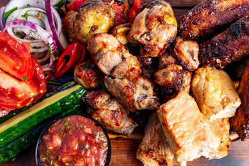 Grilled meat platter featuring assorted meats and fresh vegetables