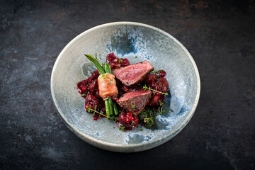 Traditionally roasted fillet of saddle of venison with chestnuts, bacon-wrapped bean sticks and...