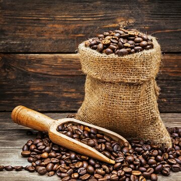 Makro von Kaffeebohnen im Jutesack mit einem Holzl&ouml;ffel (Kozept Kaffeehandel)