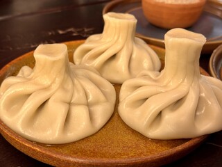 Boiled khinkali with pork and beef on a beautiful plate on the table in a restaurant. Close-up