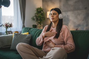Fototapeta premium one woman doing guided meditation yoga self care practice at home