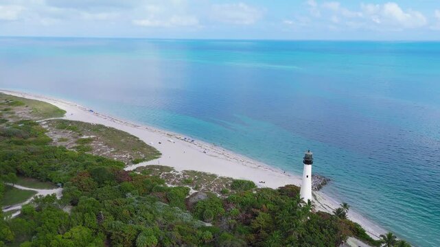 Drone footage of Key Biscayne Lighthouse in shoreline with seascape and green vegetation
