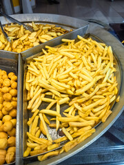 Golden fried snacks on display in a bustling street market during evening hours